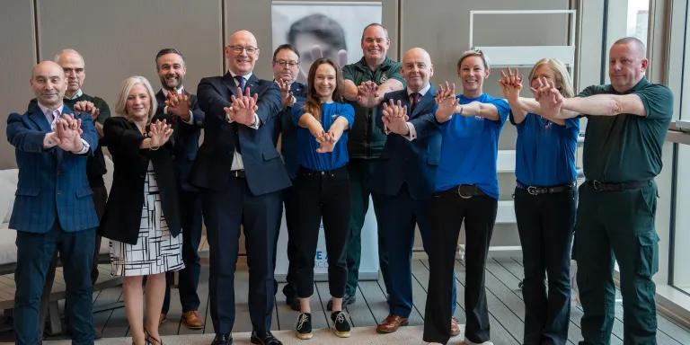 First Minister of Scotland John Swinney poses with a host of people at the announcement of £2.5 million into new defibrillators across the country