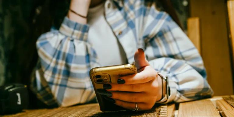 An abstract image of a young person holding a mobile phone