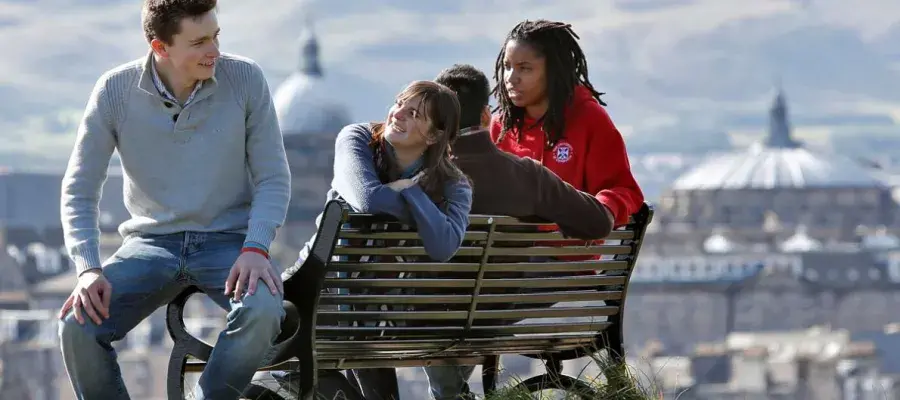 People sitting by a bench