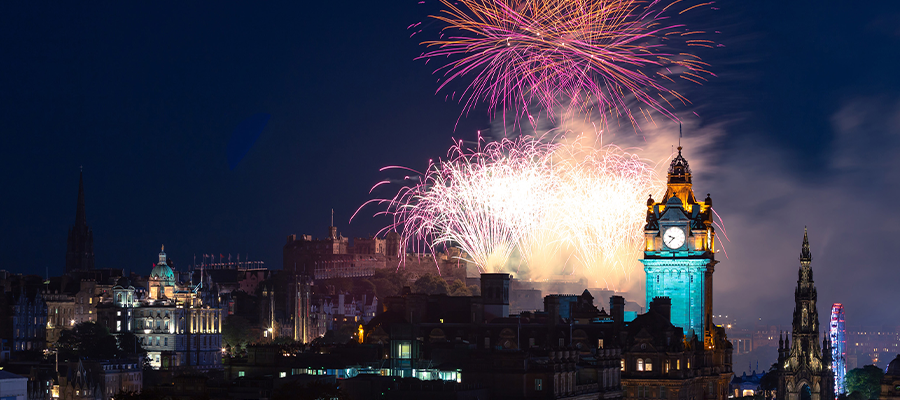 the city of Edinburgh at night with fireworks