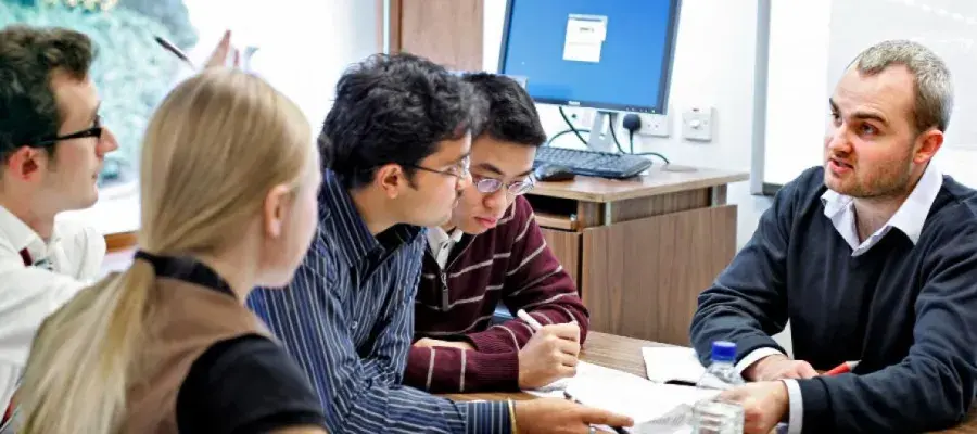 Group of students talk together in classroom 