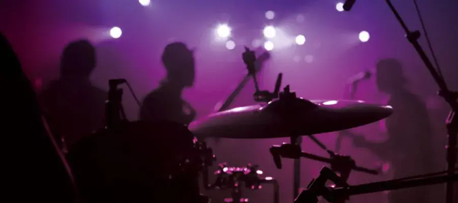 Close up of cymbal of a drum kit with band playing in background