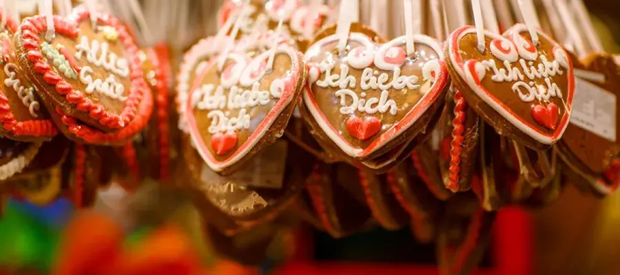 Strings of heart-shaped gingerbread biscuits with German writing in icing