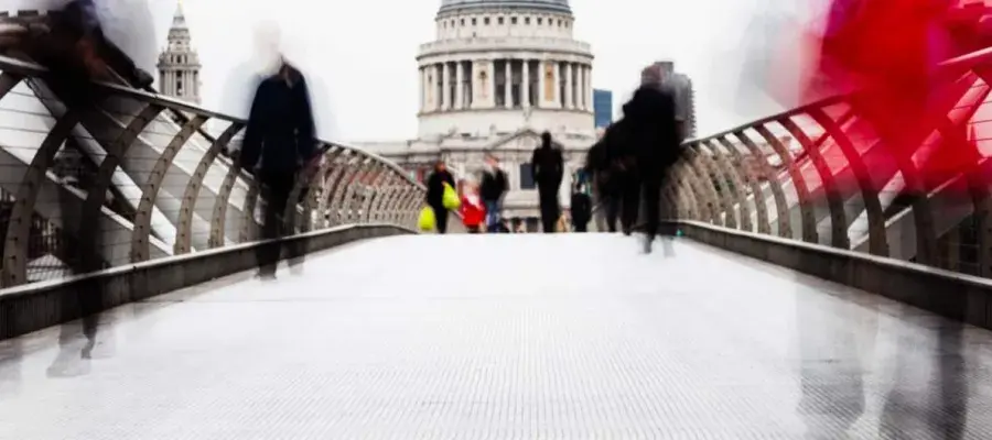 People in motion walking across a bridge
