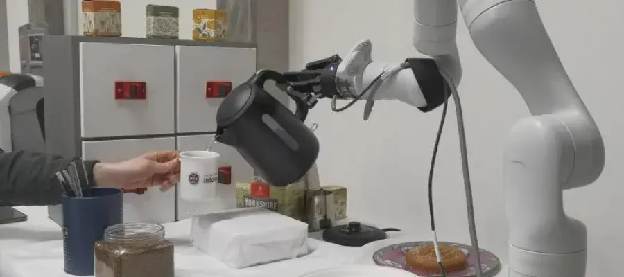 Robot arm holding kettle over mug 