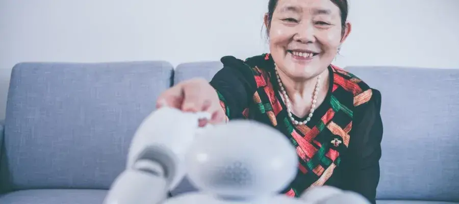 Older lady holding hands with robot