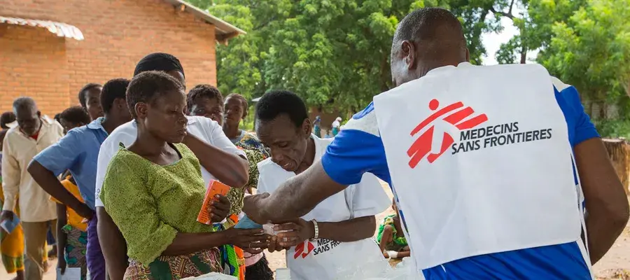 A Medecins Sans Frontières aid worker distributes malaria treatment drugs to flood victims in Malawi