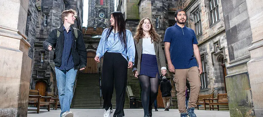 group of students walking down steps outside old building in edinburgh