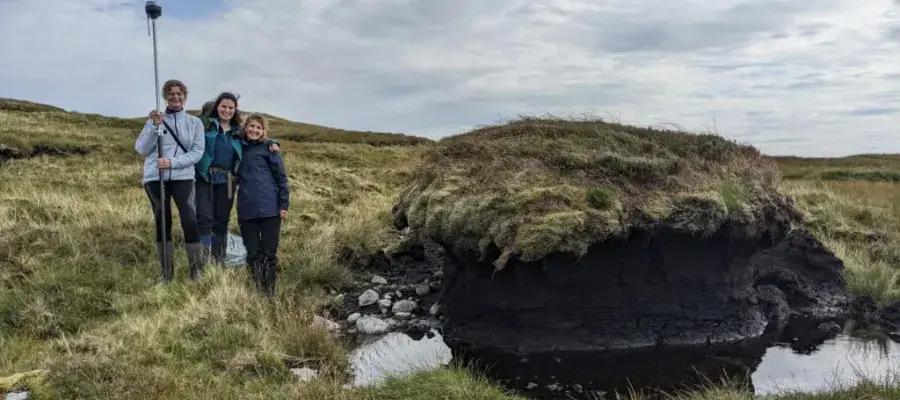 Three PhD students doing fieldwork in peatland