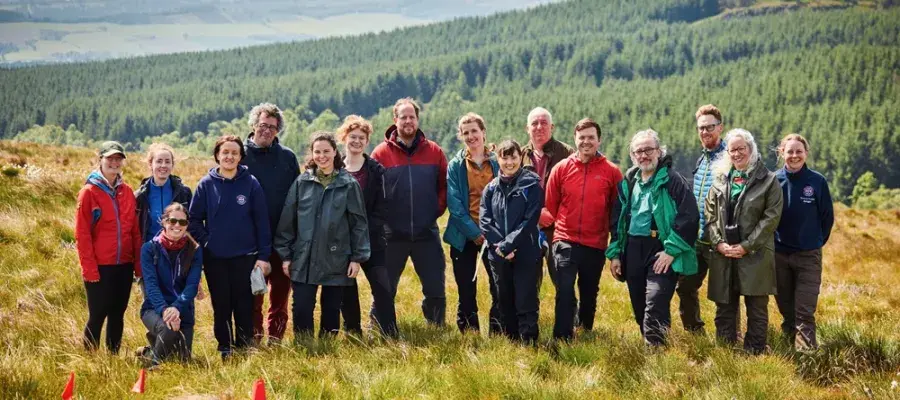 (L-R) Prof Caroline Nichol, Prof Marc Metzger, Rachel Orchard, Mareike Feldmann, Prof Rob Ogden, Tilda Tarrant, Dr Nicholle Bell, Dr Iain McNicol, Dr Georgios Xenakis, Dr Annie Yang standing on moorland at Drumbrae, Stirlingshire