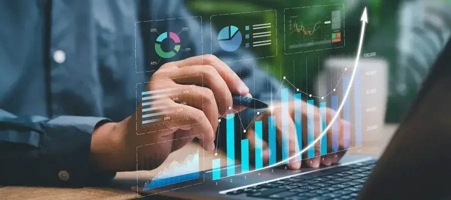 person on computer usig a pen on a holographic graph