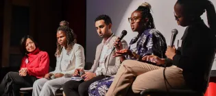 A group of five people take part in an on stage discussion. 