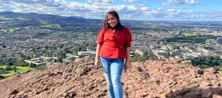 Tanisha standing on arthur's seat, view of edinburgh in the background