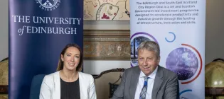 Image of Ellen Munro from Edinburgh and South East Scotland City Region Deal sitting with Peter Mathieson as he signs a Community Wealth Building Pledge