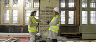 Dora Herndon, Students' Association President, and Lucy Evans, Deputy Secretary Students, inspect an exposed wall at the Teviot Row House construction site.