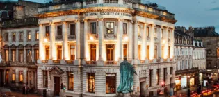 Photograph of the Royal Society of Edinburgh building (RSE) in Edinburgh, Scotland with traffic and statue in the foreground