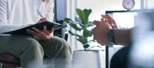 Two people sitting on chairs talking