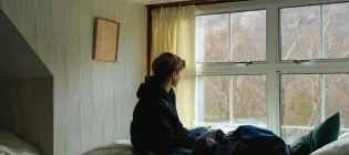 Teenager sitting on a bed