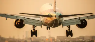 Large aeroplane taking off with buildings in the background