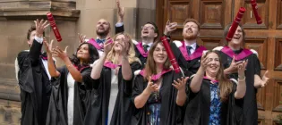 Graduates from the HCP-Med programme at the University of Edinburgh throw their degree certificate tubes into the air in front of McEwan Hall, Edinburgh