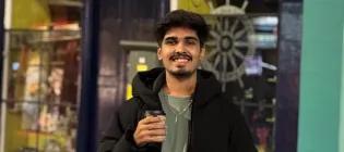 Smith student standing in victoria street Edinburgh with hot chocolate