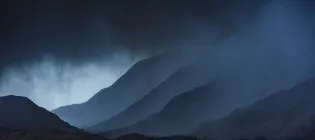 Dark rain clouds over a Scottish mountain range