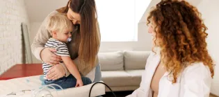 Mother and son visiting female doctor in paediatrician's office