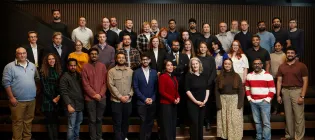 36 cohort members standing and looking to camera 