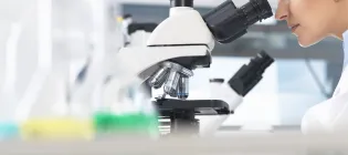 A female scientist looking through a microscope