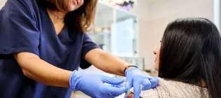 Young woman receiving a vaccination from a nurse