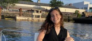 lauren sits on a boat on the water