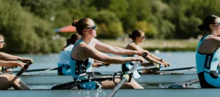 Women rowing with one female at the focus and others in background