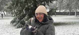 a student smiles while covered in snow