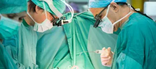 Heart surgeons during a heart operation, wearing scrubs