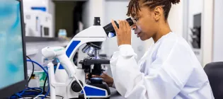 Female scientist looking through a microscope in a laboratory