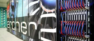 A close-up image of the ARCHER2 supercomputer, showing a large rack of thick blue and red cables