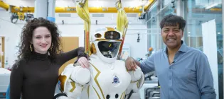PhD student Elle Miller (left) and Professor Sethu Vijayakumar (right) standing with the NASA Valkyrie humanoid robot