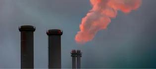 chimneys spew out smoke into the air