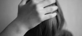 Black and white image of child with head in hands