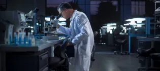 A scientist looking at a DNA sample under a microscope in a laboratory