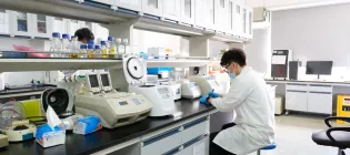 A scientist in a white coat working in a lab