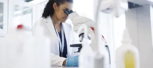 A female scientist looking through a microscope in a laboratory