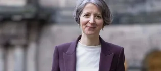 Image of Professor in front of a University Building