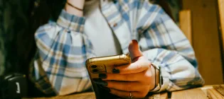 An abstract image of a young person holding a mobile phone