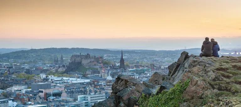 couple sitting on salisbury crags in Edinburgh