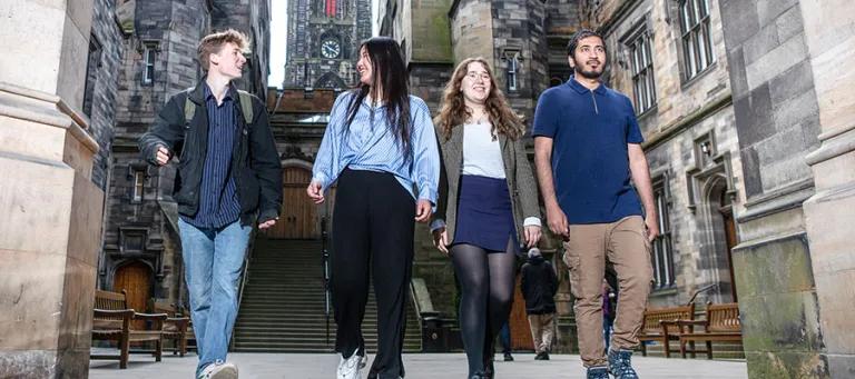 group of students walking down steps outside old building in edinburgh