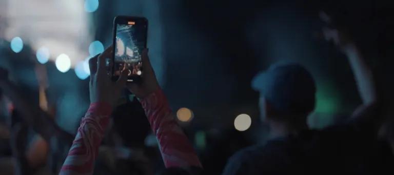 person holding phone at concert