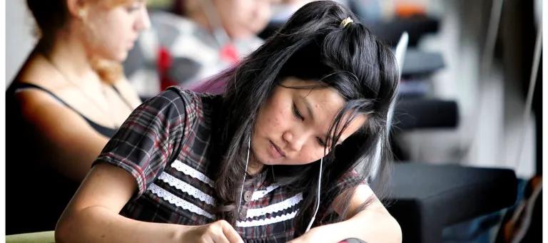 Focussed student writing in notepad