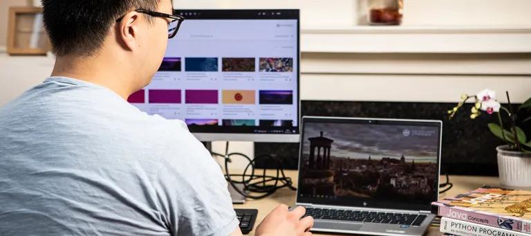 Data Science student uses a laptop with a monitor