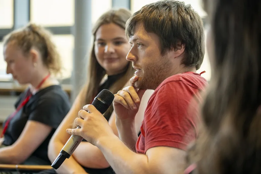 Marc, a Insights student participant speaks during Insights Panel in Scotland during June 2024 event. 2 other panellists look on